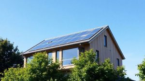 Casă pasivă modernă cu panouri solare pe acoperiș.